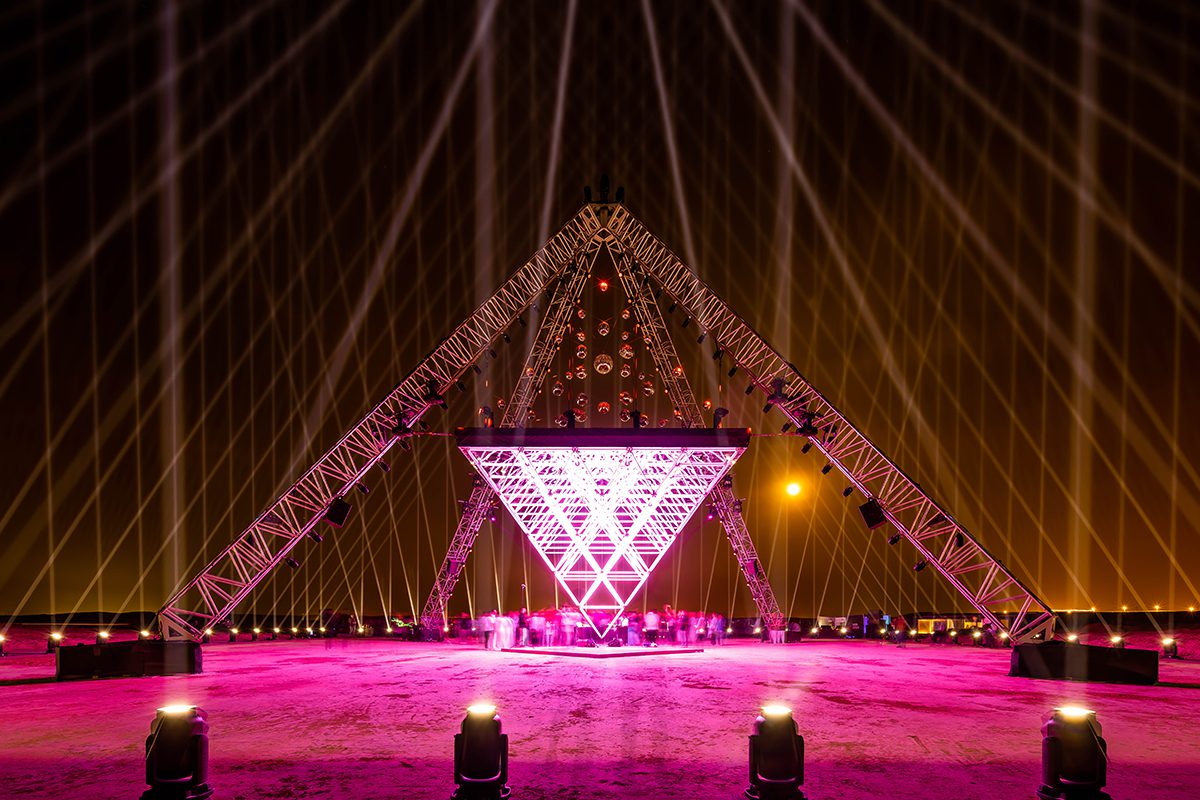 An upside down pyramid installation with pink lights on it