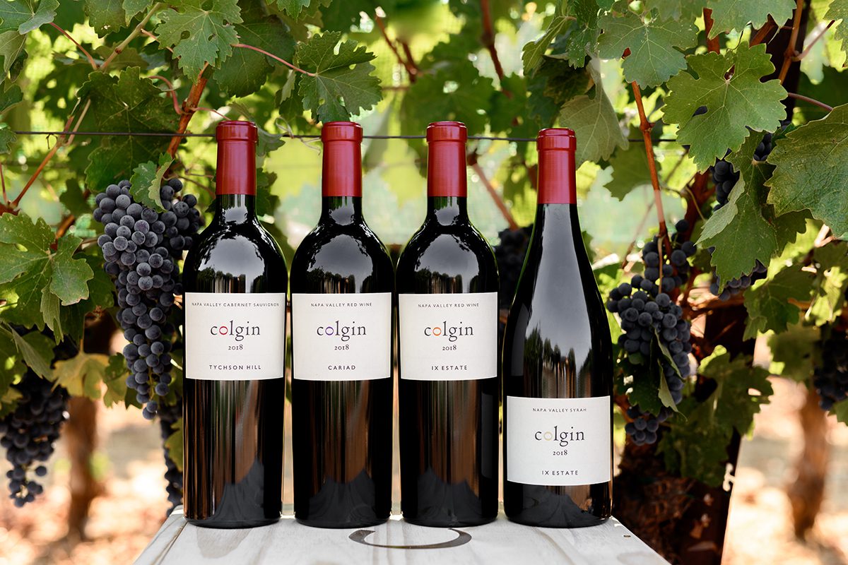 wine bottles on a table in front of trees