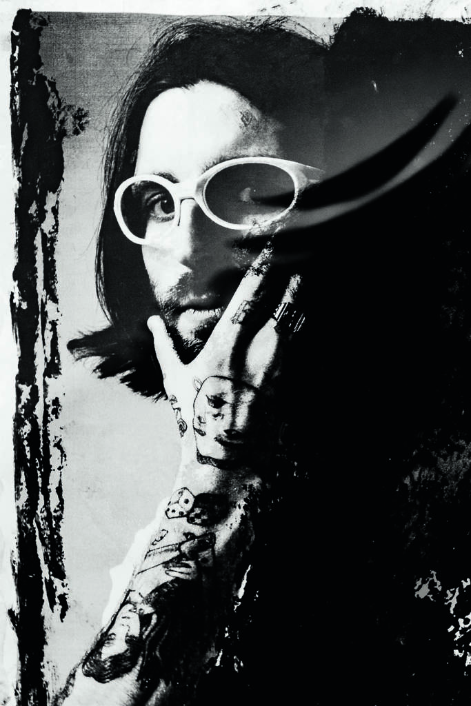A man with his tattooed hand on his face