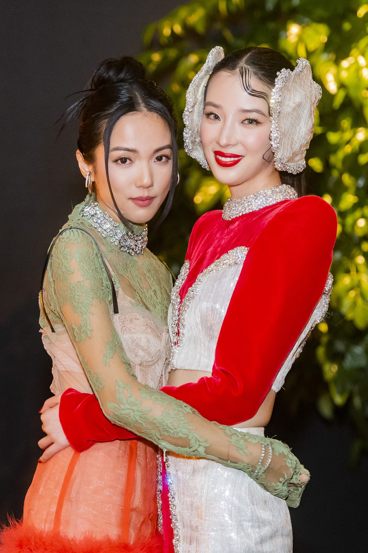 two women with their arms arund their waist and one is wearing diamond ear muffs