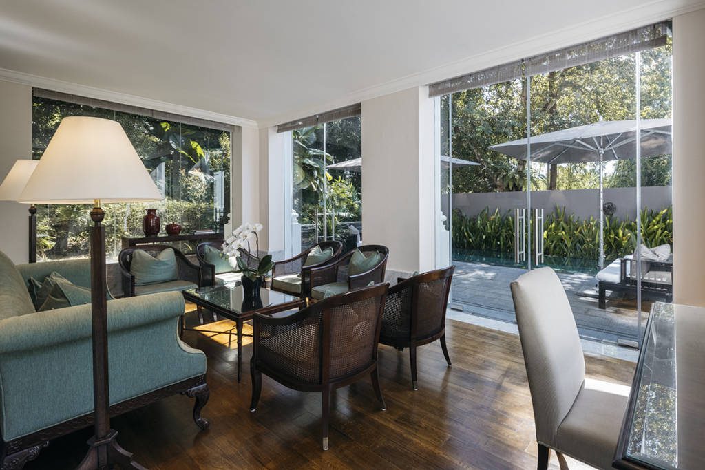 a sitting area with blue and wooden chairs and sofas