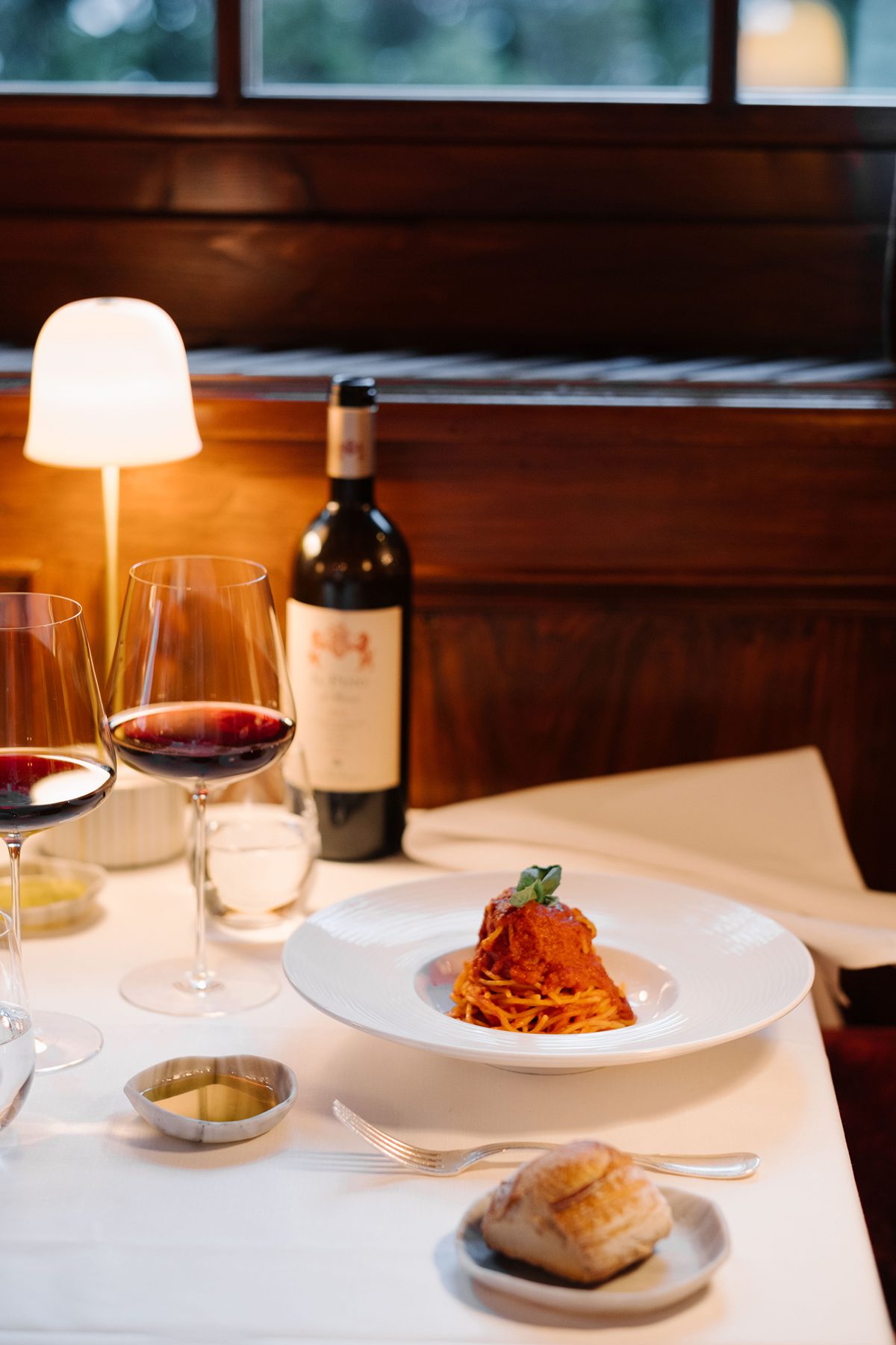 a table with pasta, bread and wine on it