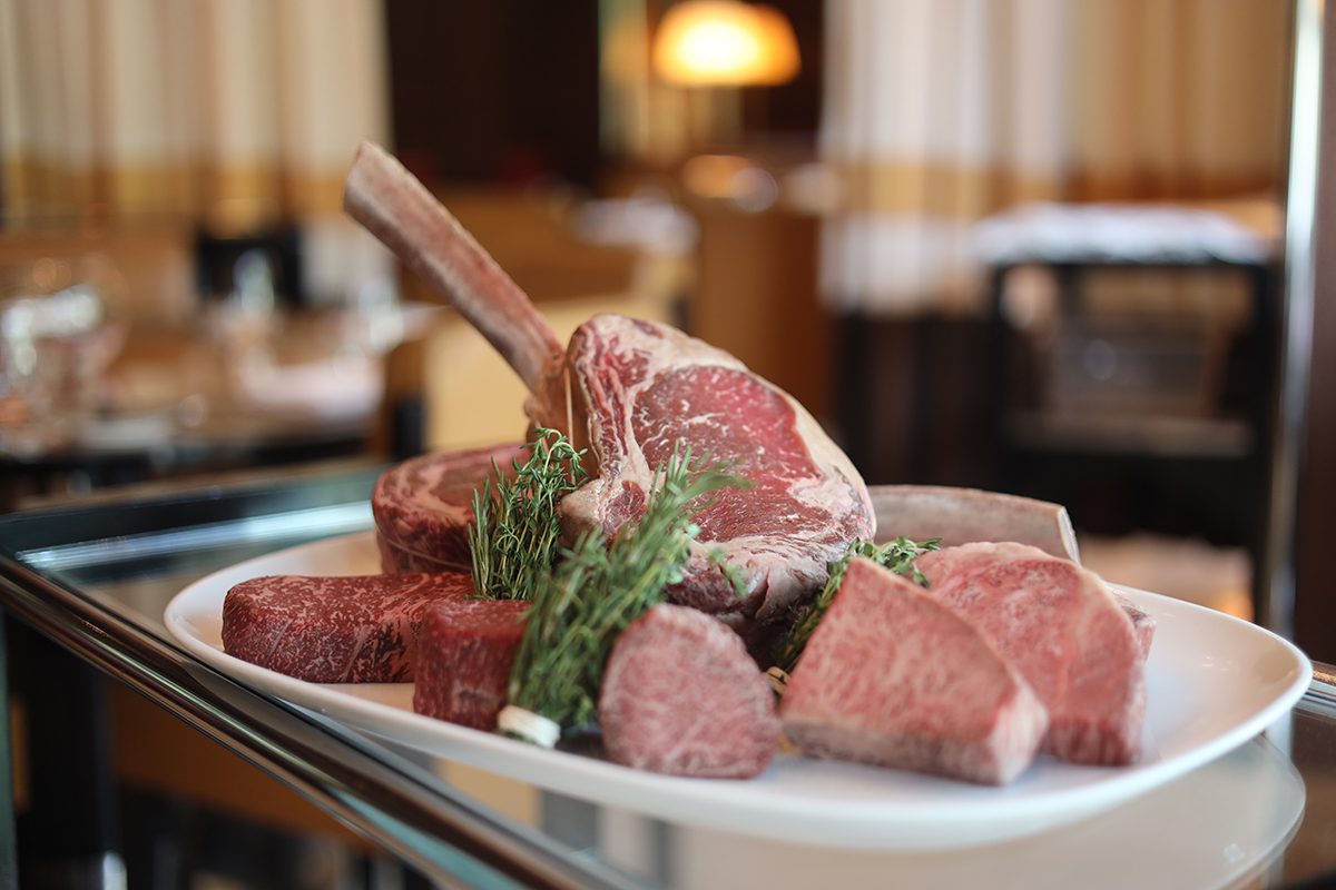 raw steak with rosemary on a tray