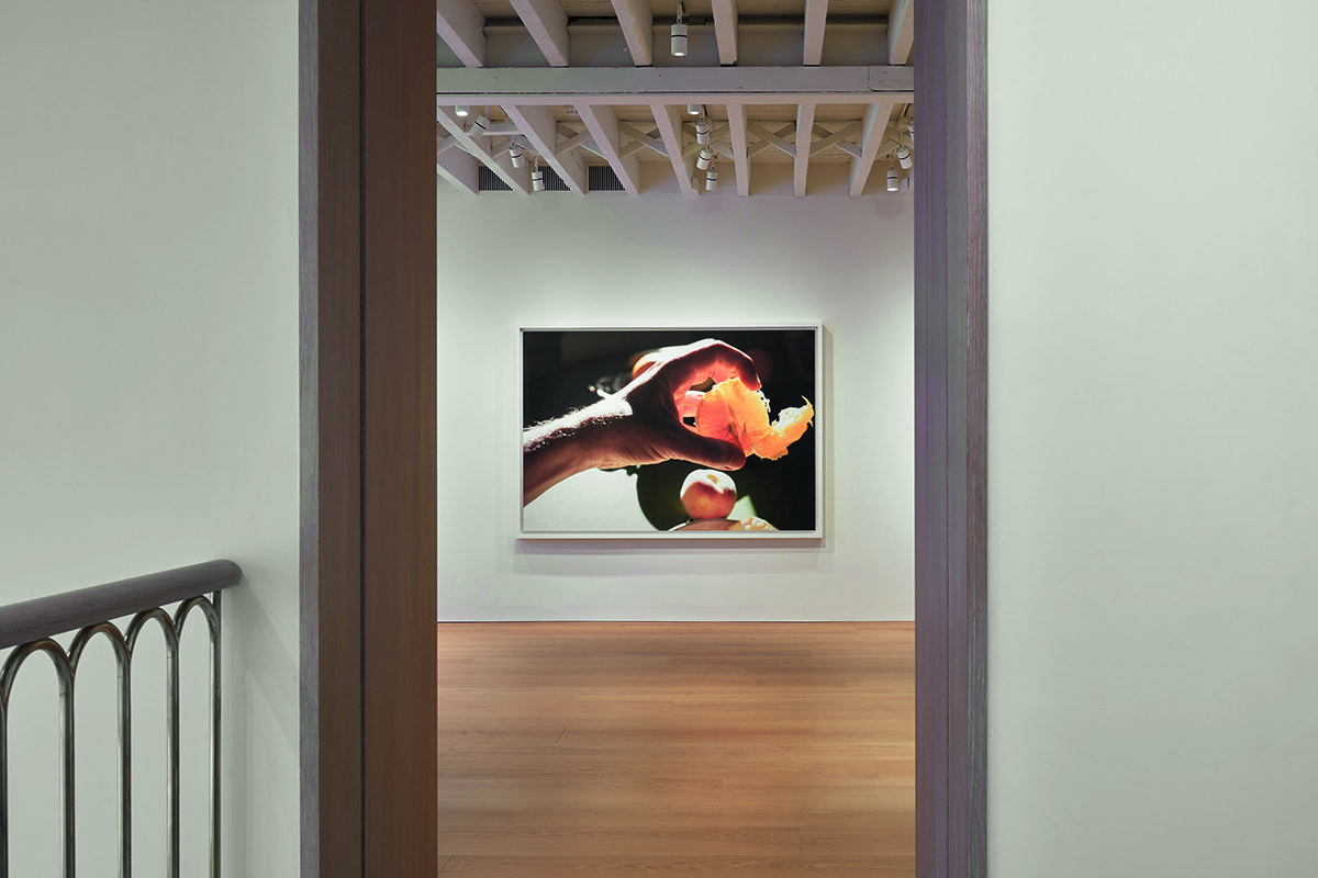 A painting on a wall of a hand and a peach