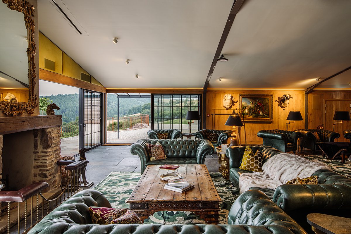 A sitting room with green sofas leading to a terrace