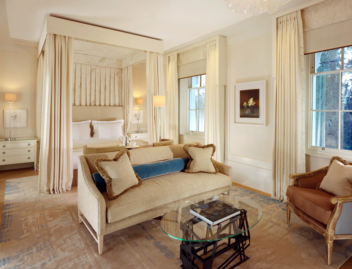 A bedroom with a cream bed and sofa