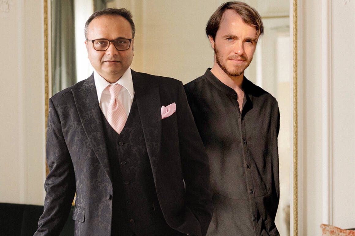 two men standing together wearing black