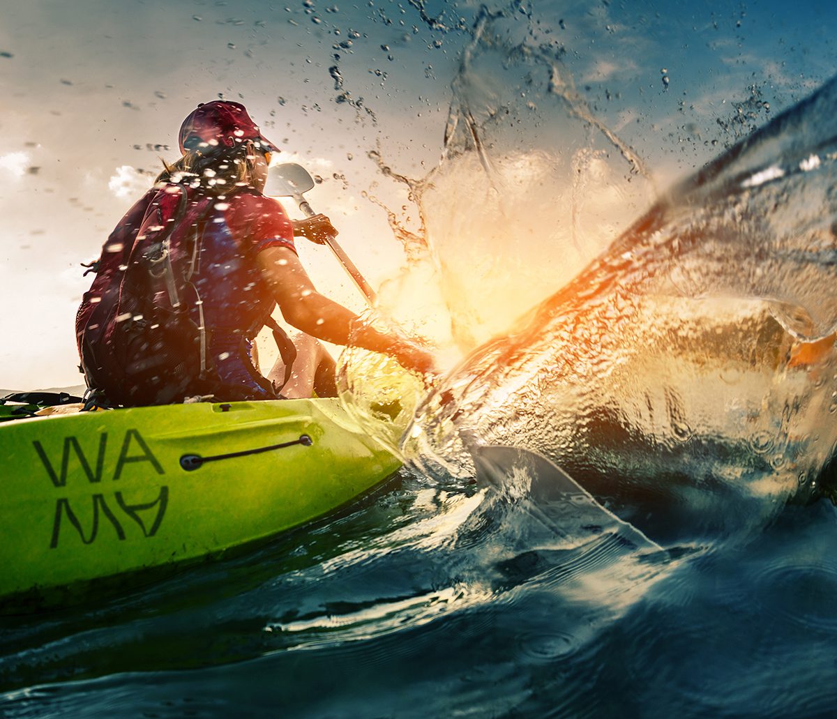 A person using a row in a yellow kayak
