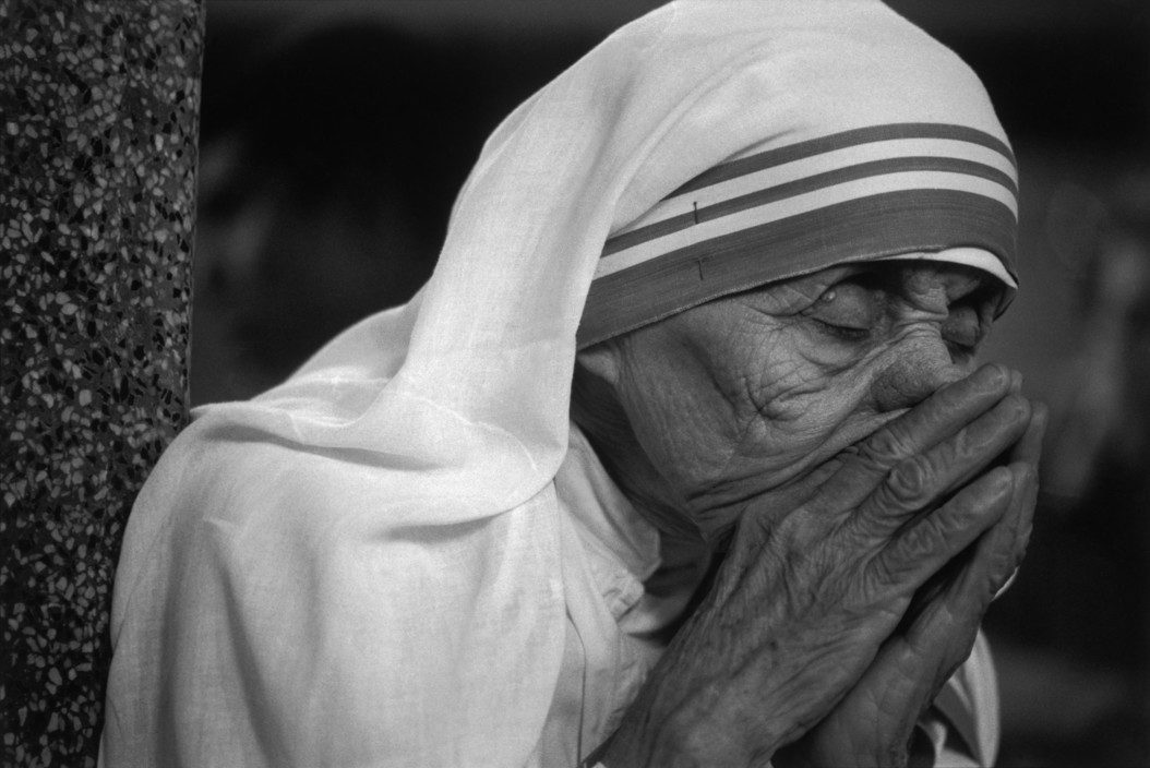 Mother Teresa putting her hands to her mouth in prayer