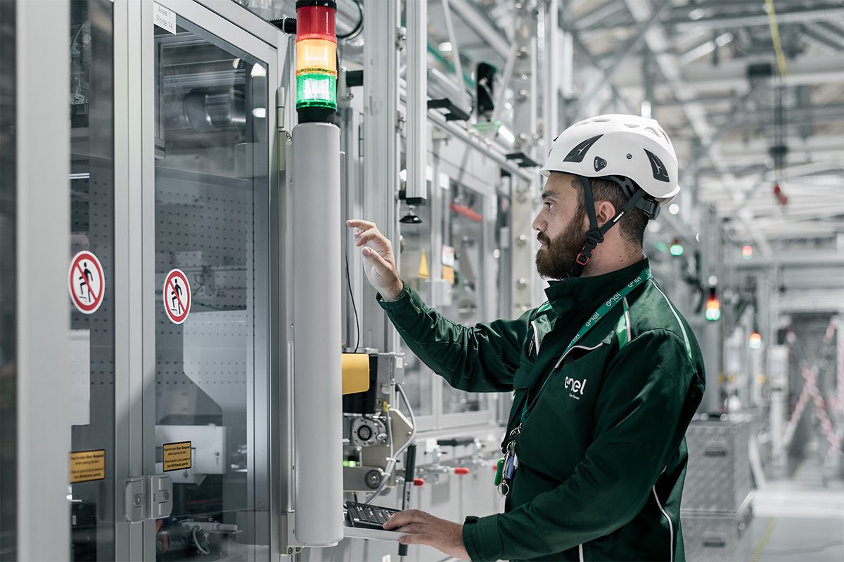 A man wearing a green jumper working in a factory