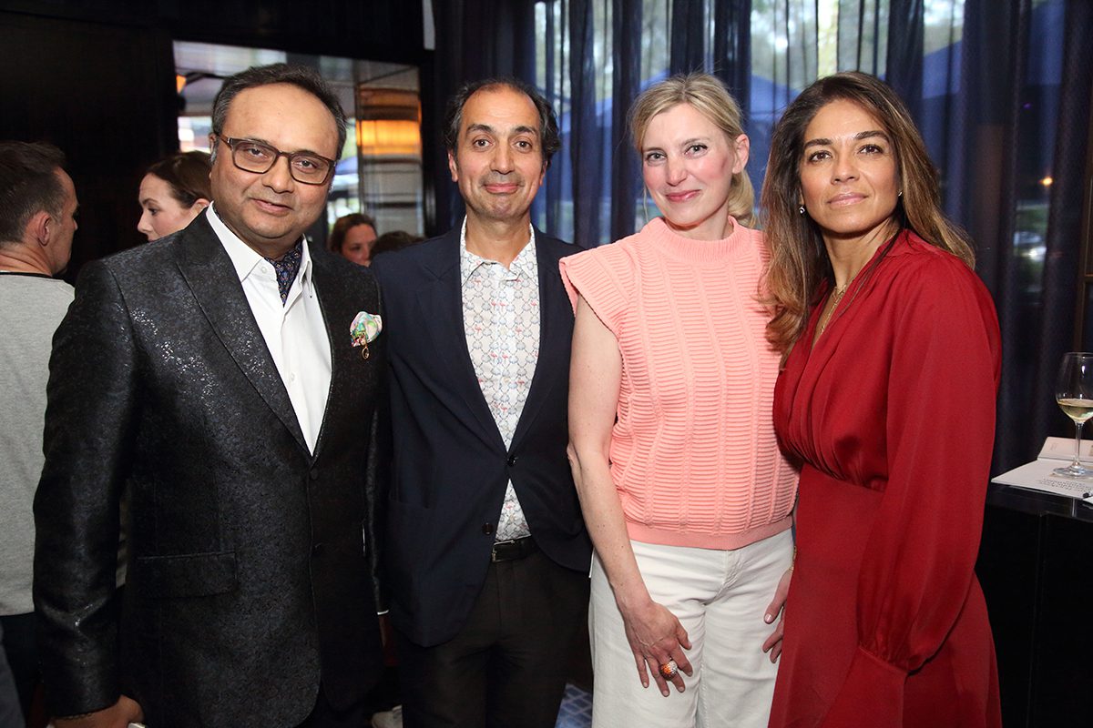Two men standing next to women wearing pink and red