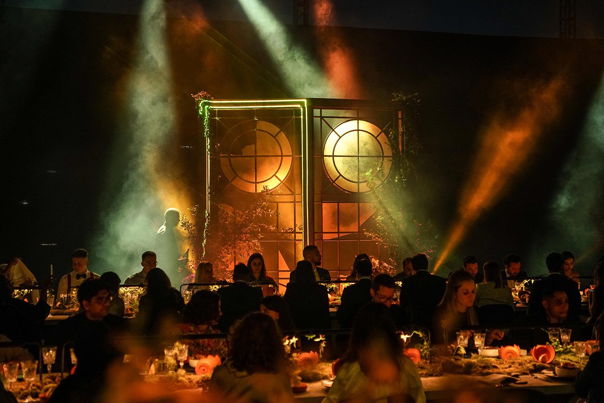 people sitting having dinner in a room lit up with orange and yellow lights