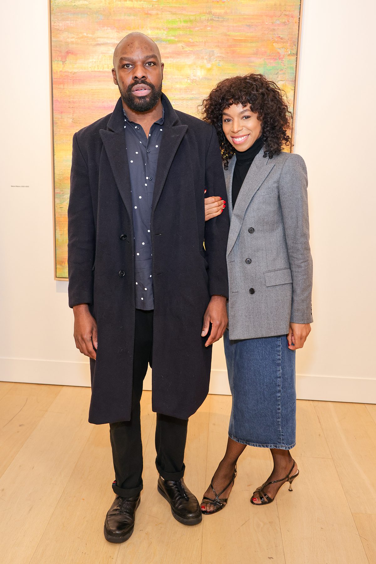 Two men and women standing together wearing blue and grey outfits