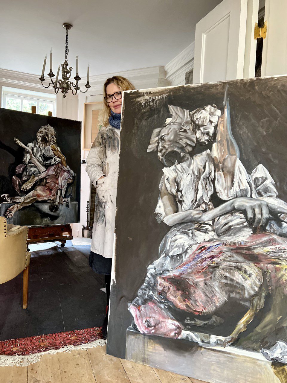 A woman standing behind a painting