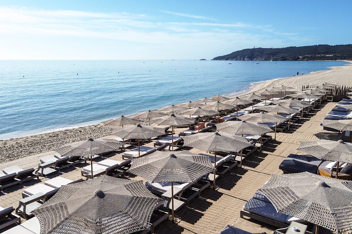 A beach with sun beds and umbrellas