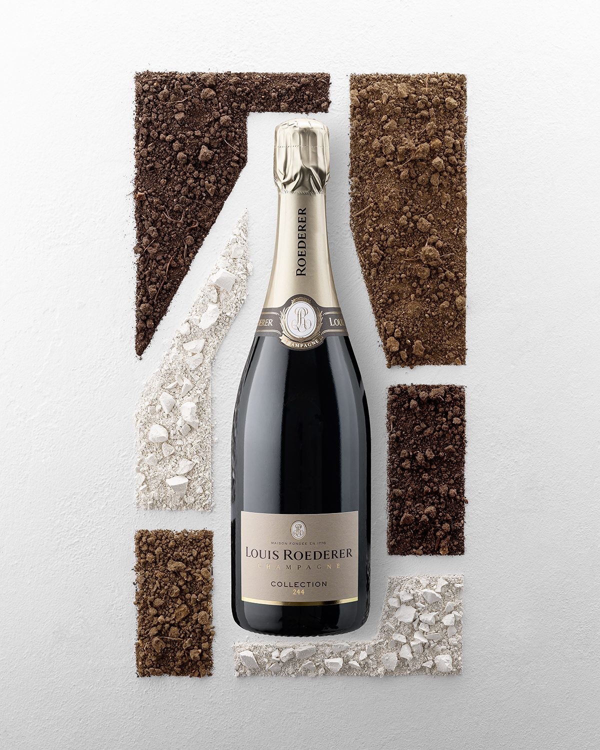 A bottle of champagne surrounded by soil and chalk