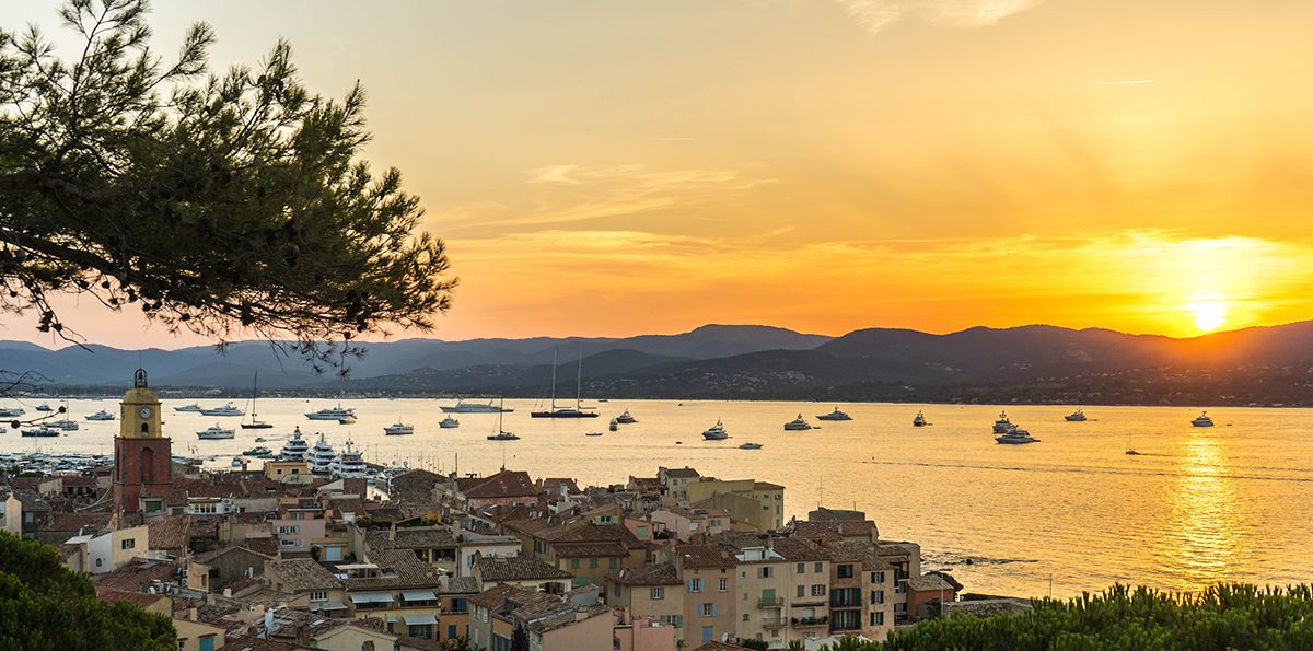 A view of boats in the sea and a sunset