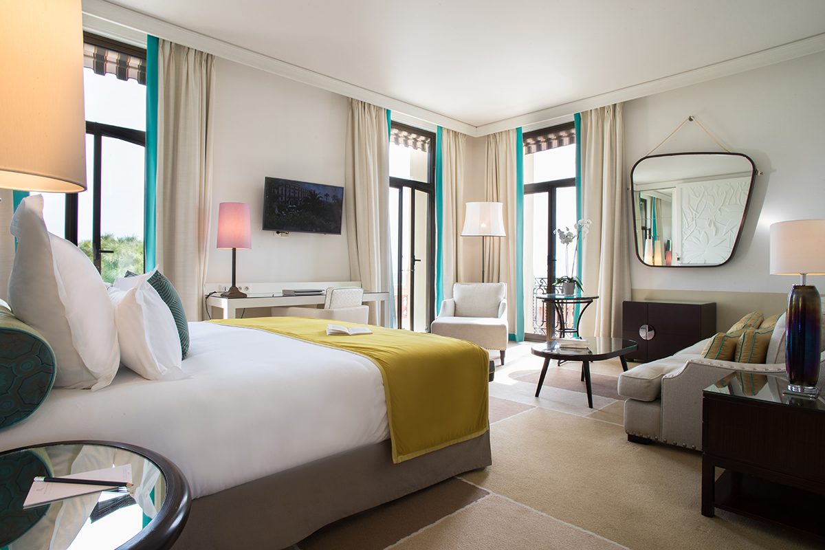 A bedroom with a yellow throw on the bed
