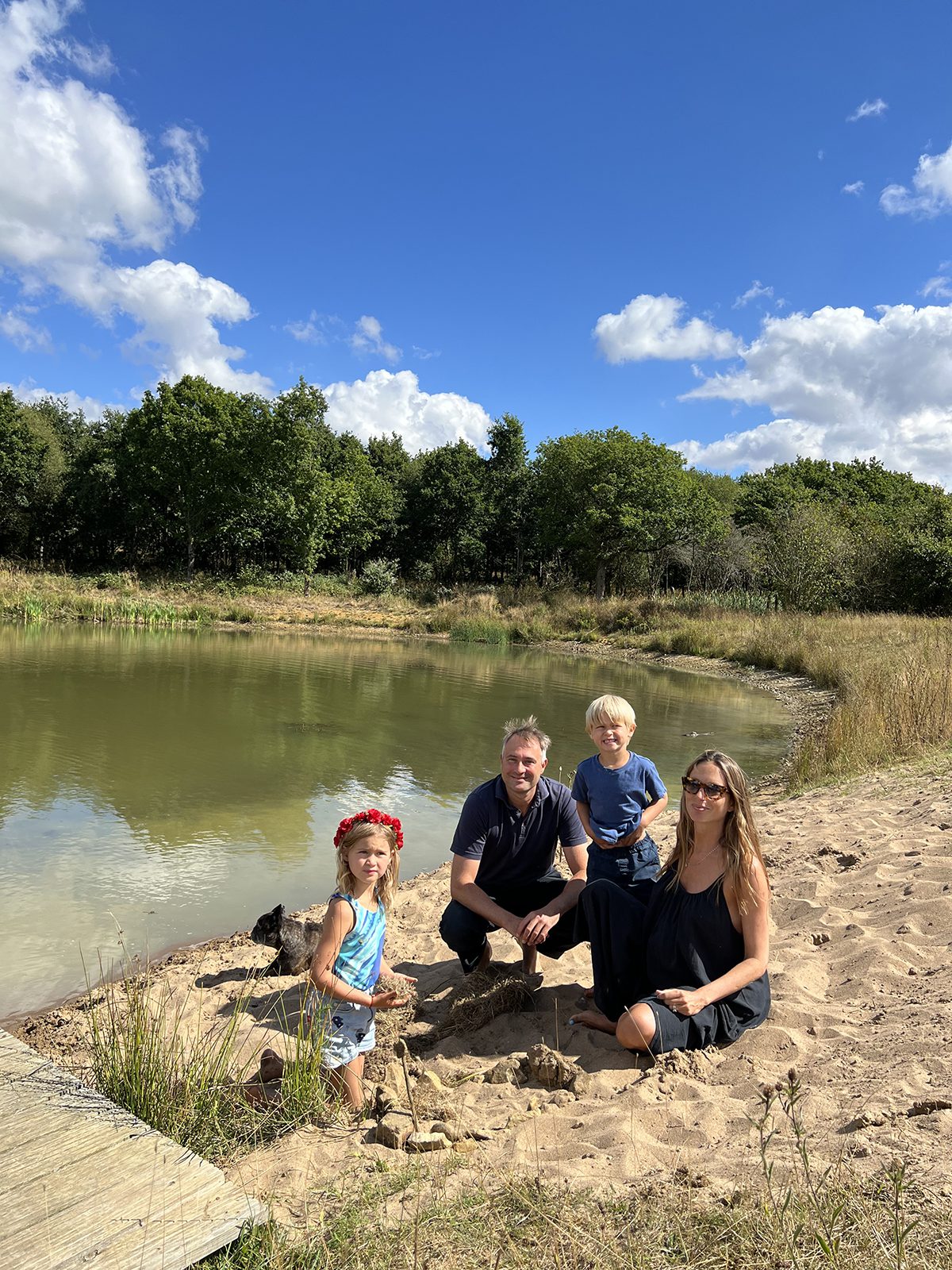A family sitting on the ground by a river