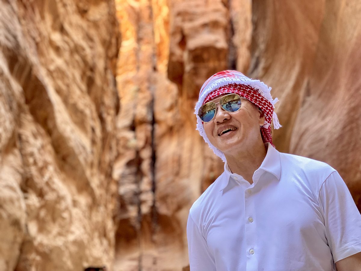 A man wearing a red and white turban in a dessert