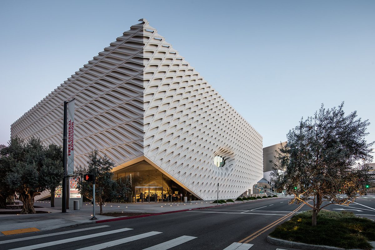 A triangle shaped white building on a busy road