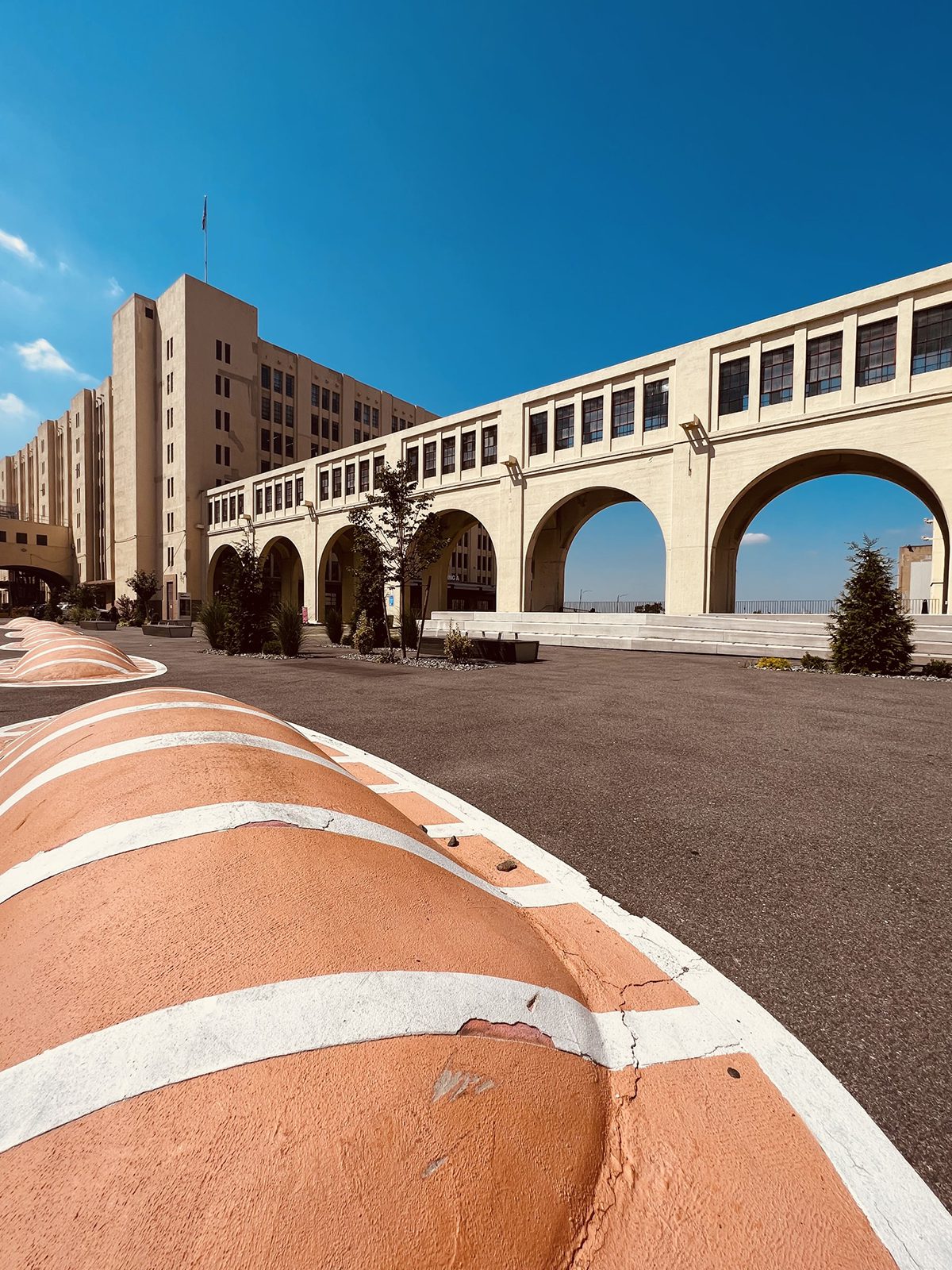 red and white blocks on the ground by a bridge and industrial building