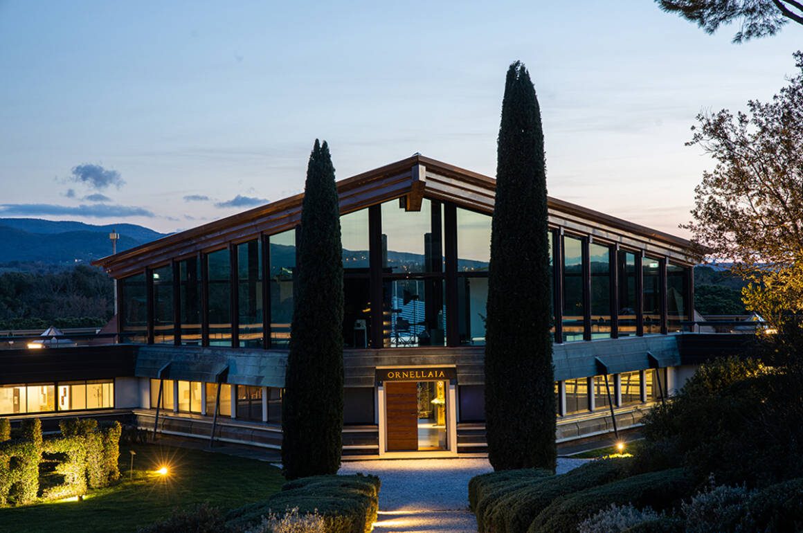 A glass and wood building that says "Ornellaia" on it