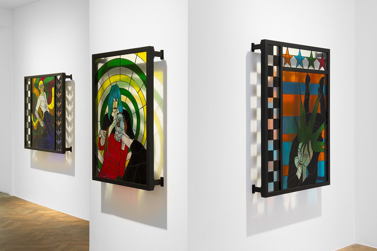 stained glass pictures hung on a wall in yellow, green, red, orange and blue