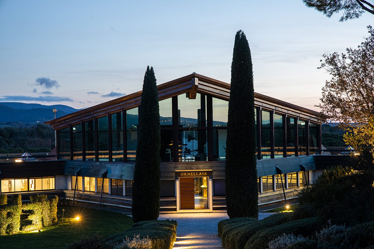 A glass and wood building that says "Ornellaia" on it