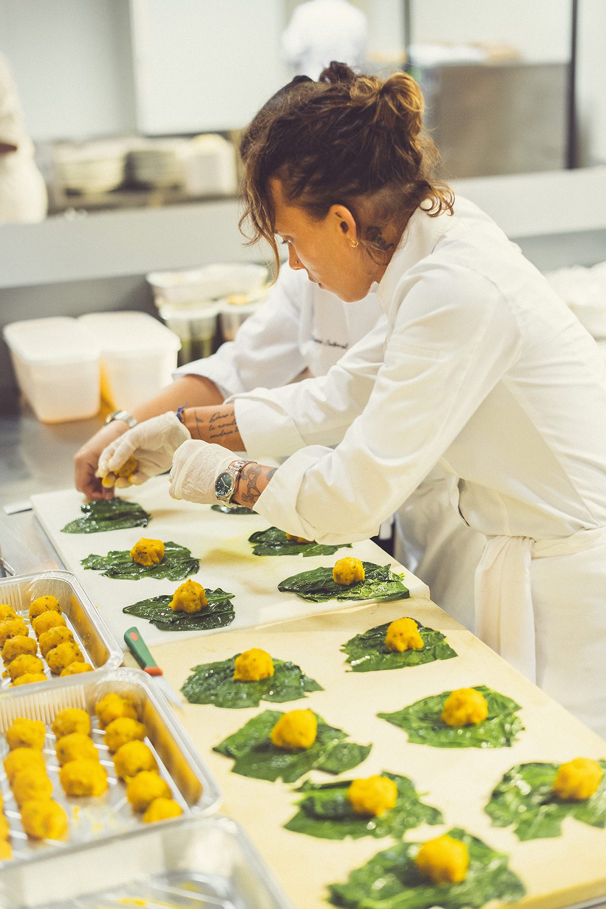A chef preparing ravioli in green leaves