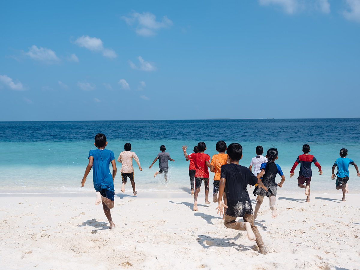 children running into the sea