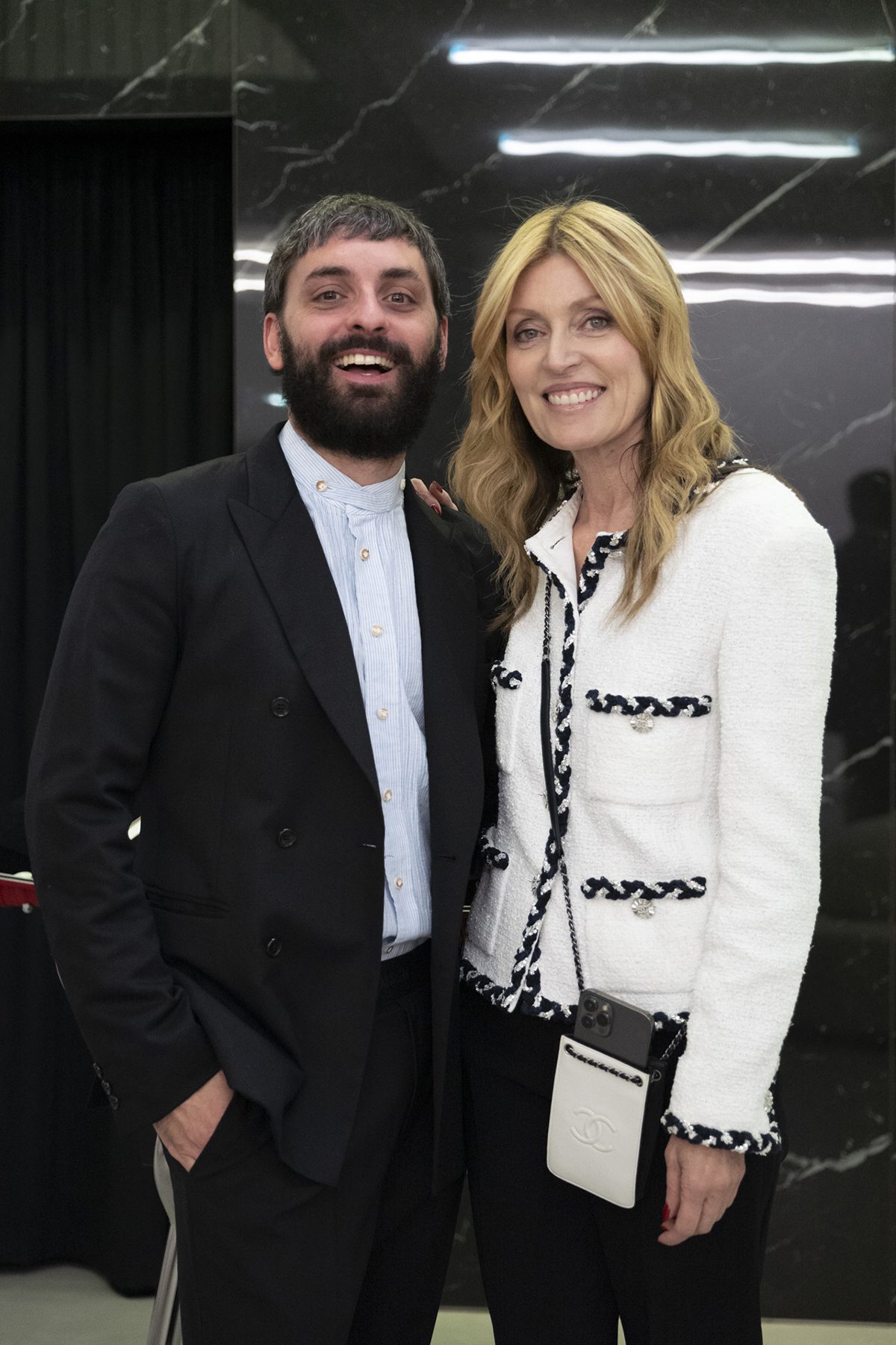 A woman in a white jacket standing next to a man in a suit