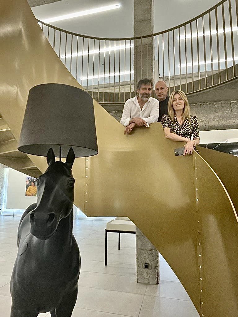 Two men and a woman standing on a gold staircase
