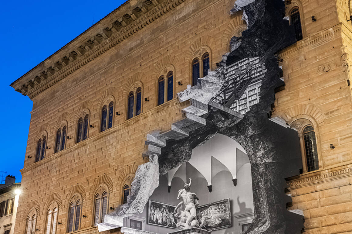 A building exterior with a picture on it showing the inside of the building in grey as if the wall has been bashed through