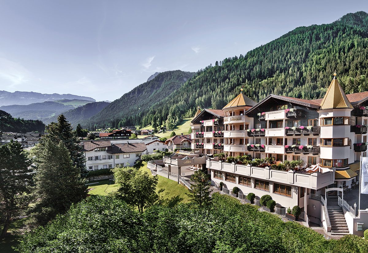 A chalet style hotel in the mountains covered in trees