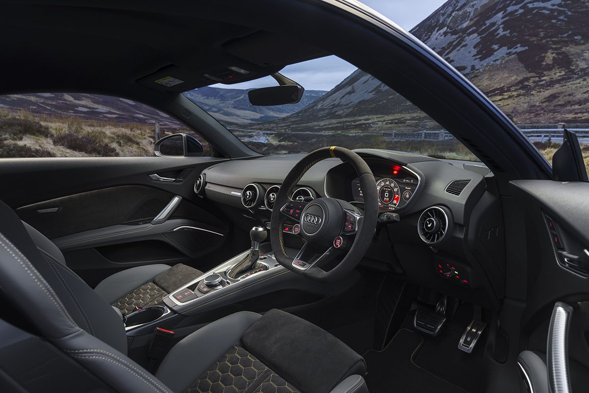 A steering wheel and car interior in black leather
