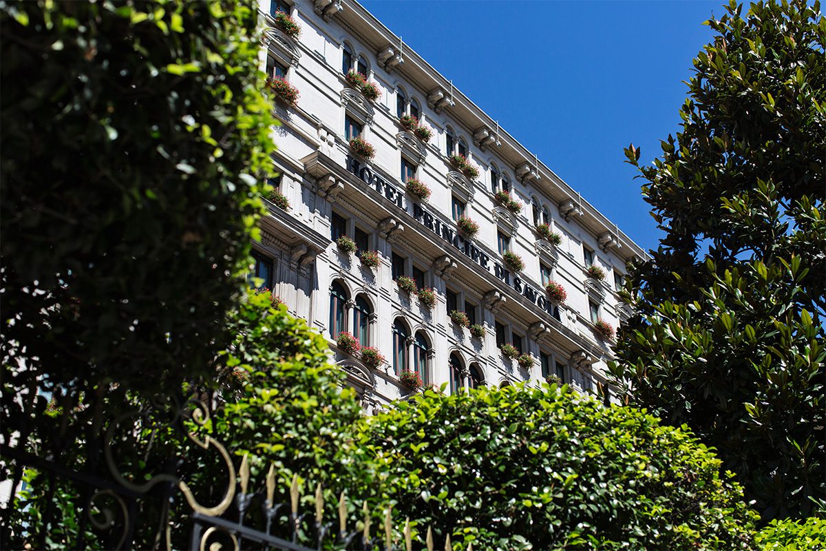 outside of a hotel with green plants and blue sky and balcony