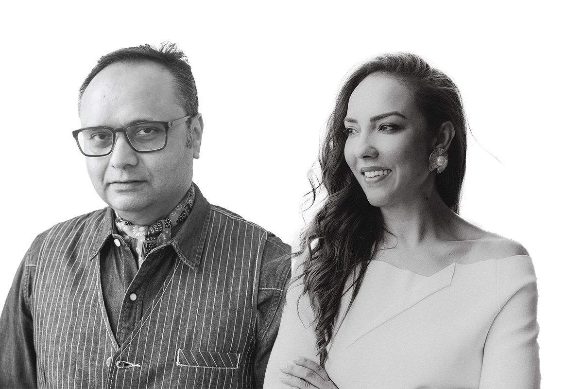 A man and woman standing next to each other in black and white 