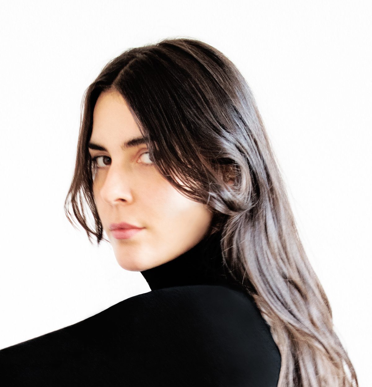 A woman with brown hair wearing a black turtleneck top 