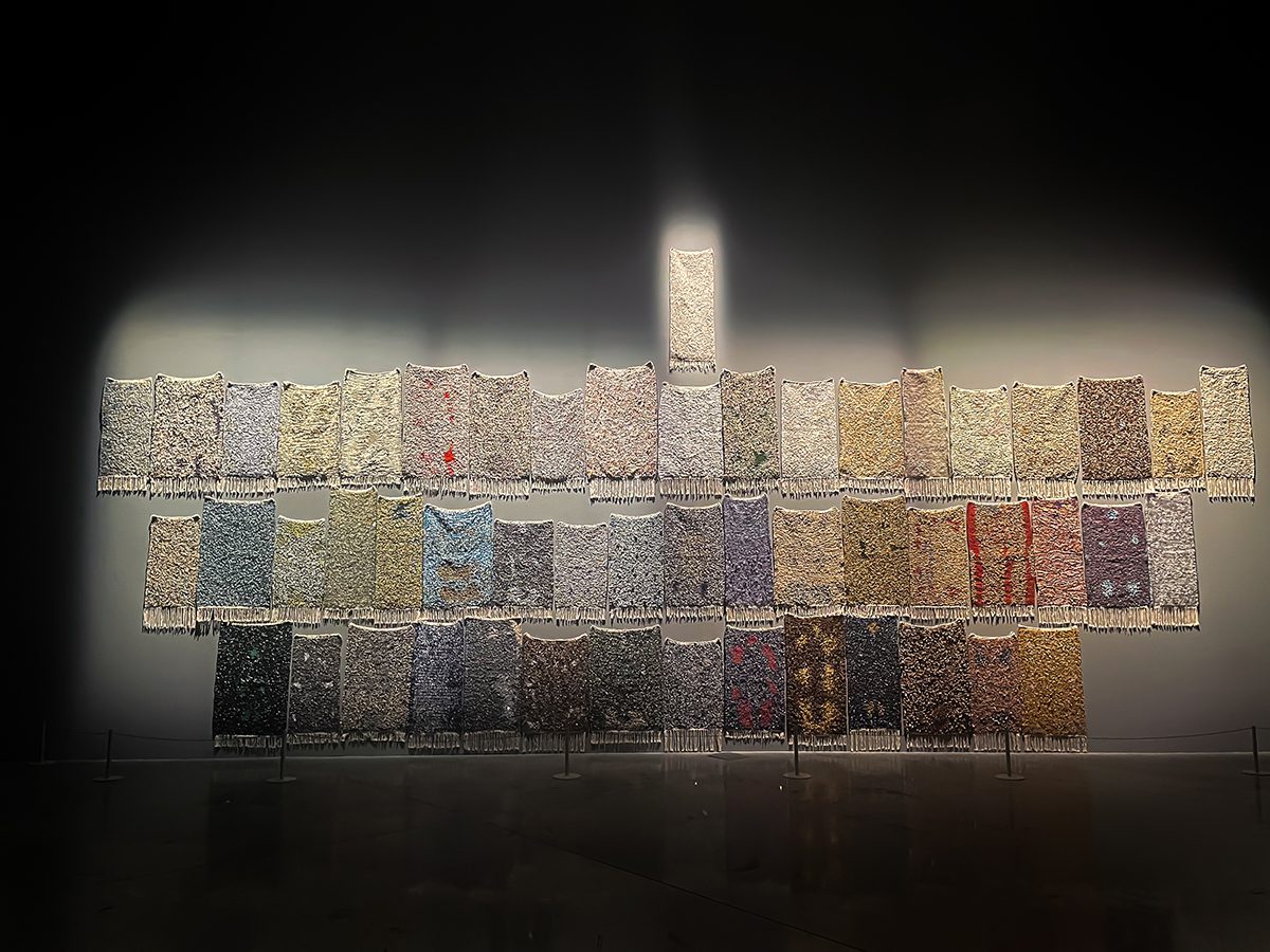 jewelled colourful prayer mats hanging on a wall