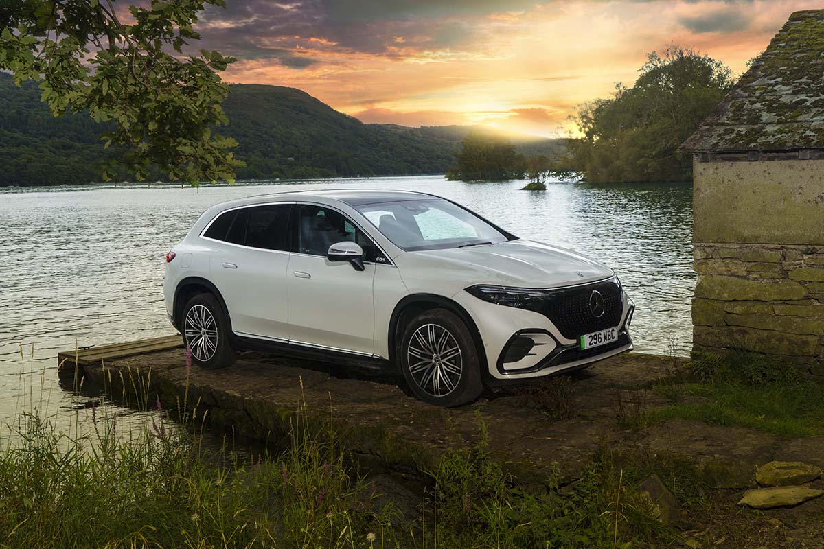A white car by a lake at sunset
