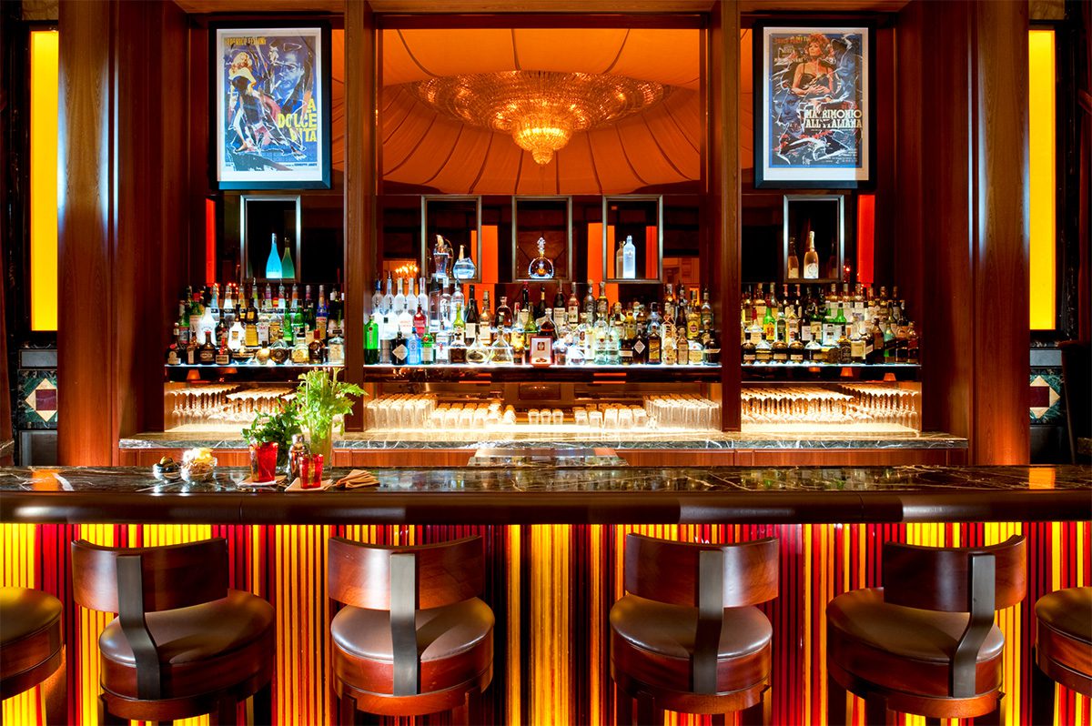 Bar with lots of drinks and lights and chairs and mirror