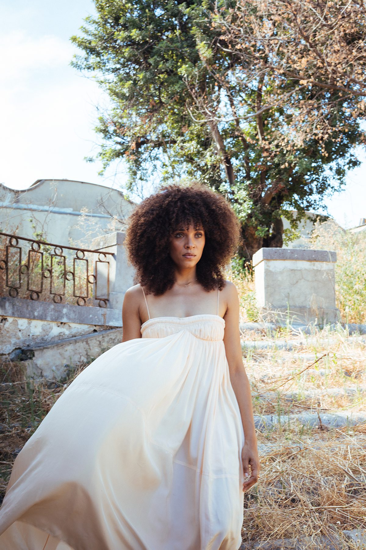 A woman wearing a white dress standing in a garden