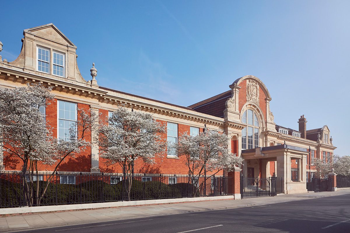 Big red brick building with trees and blue sky