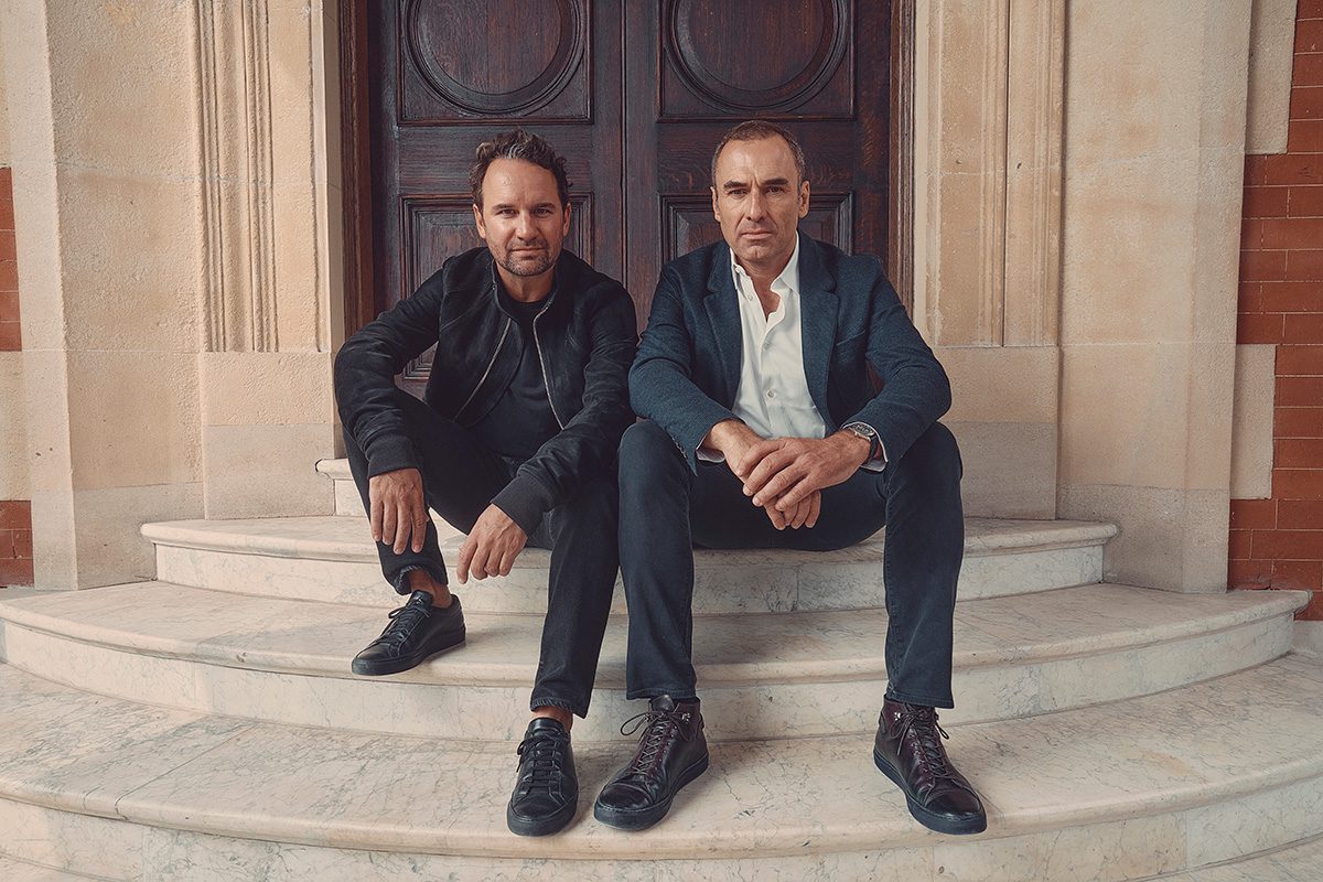 two men in suits sitting on steps