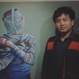 man standing next to painting