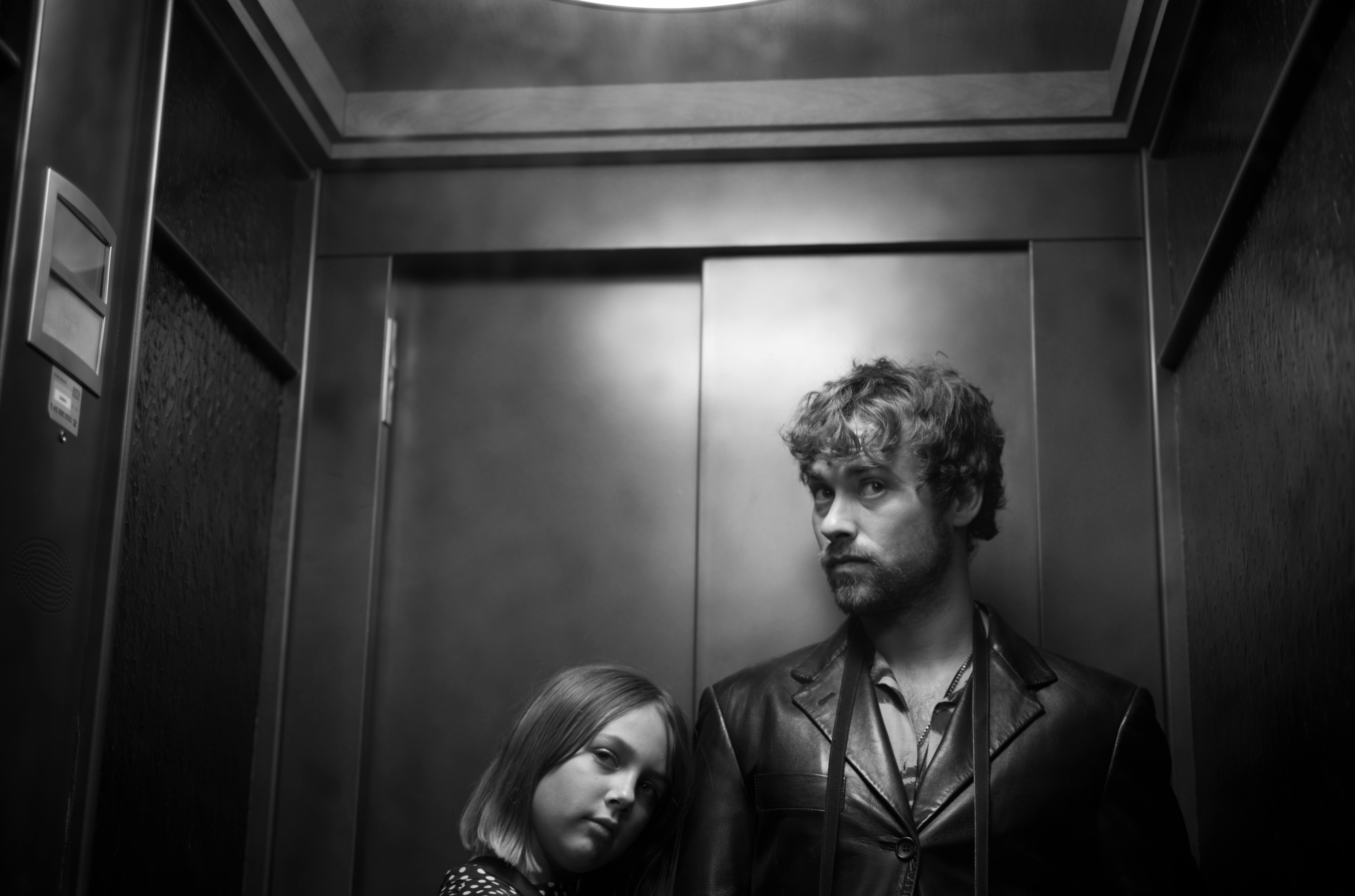 A father and daughter looking at the camera