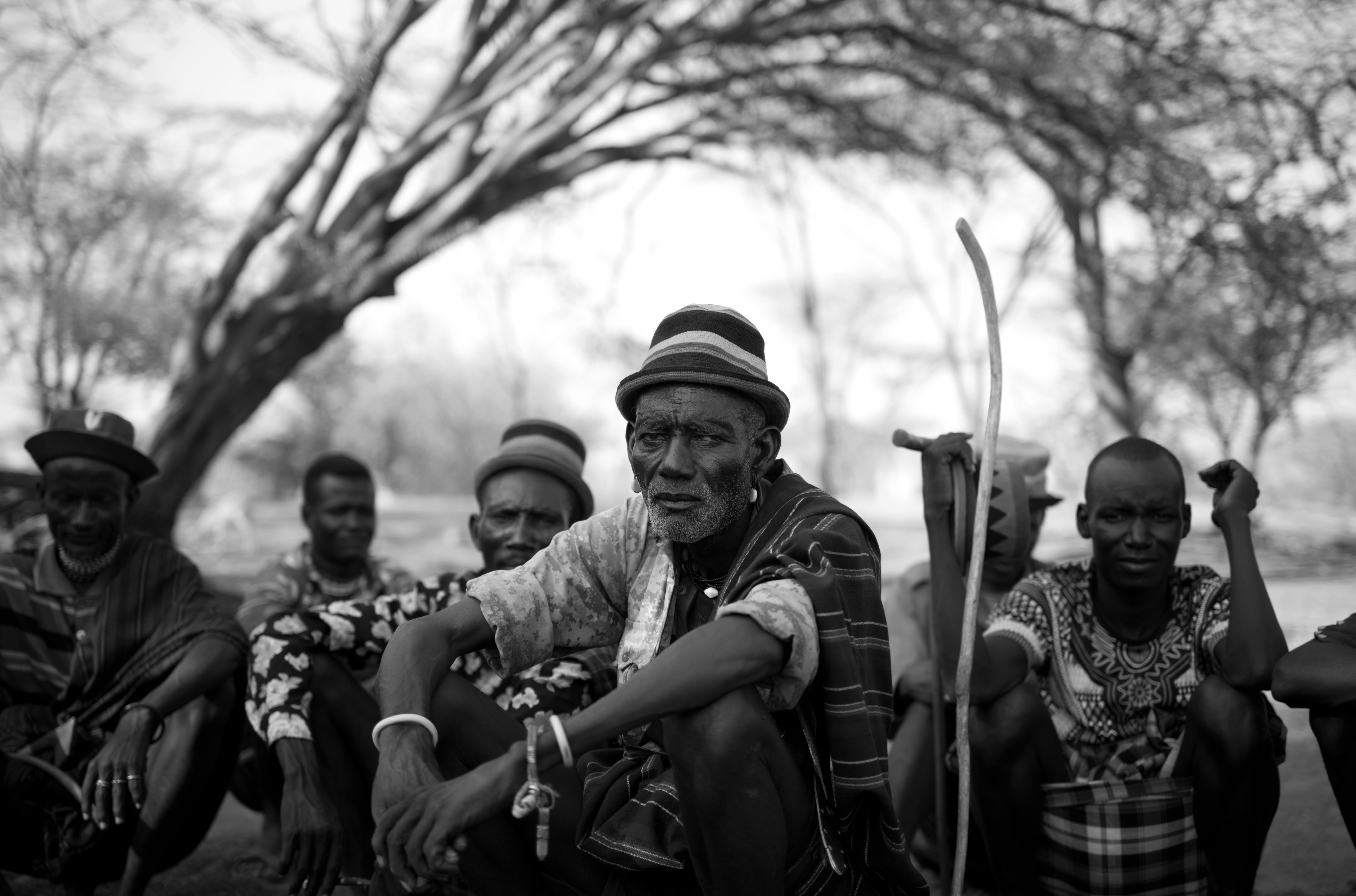 trees behind a tribesman in Kenya looking at the camera