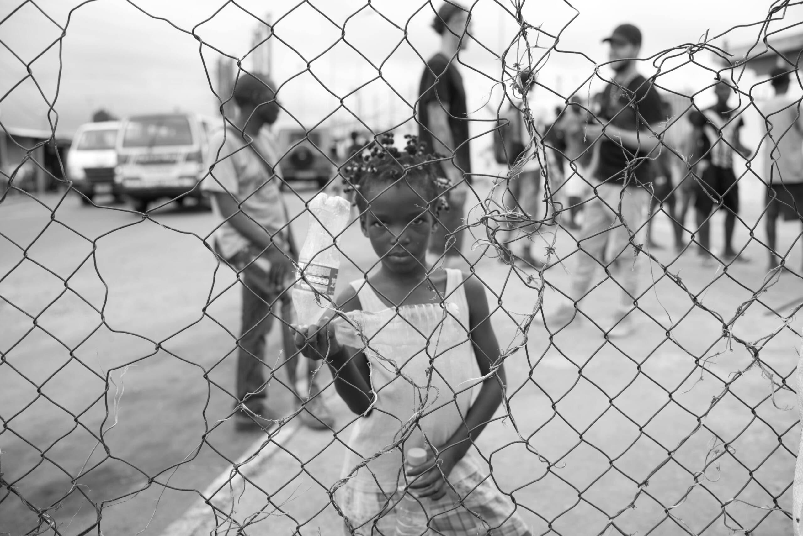 Little girl in front of wire mesh in dress