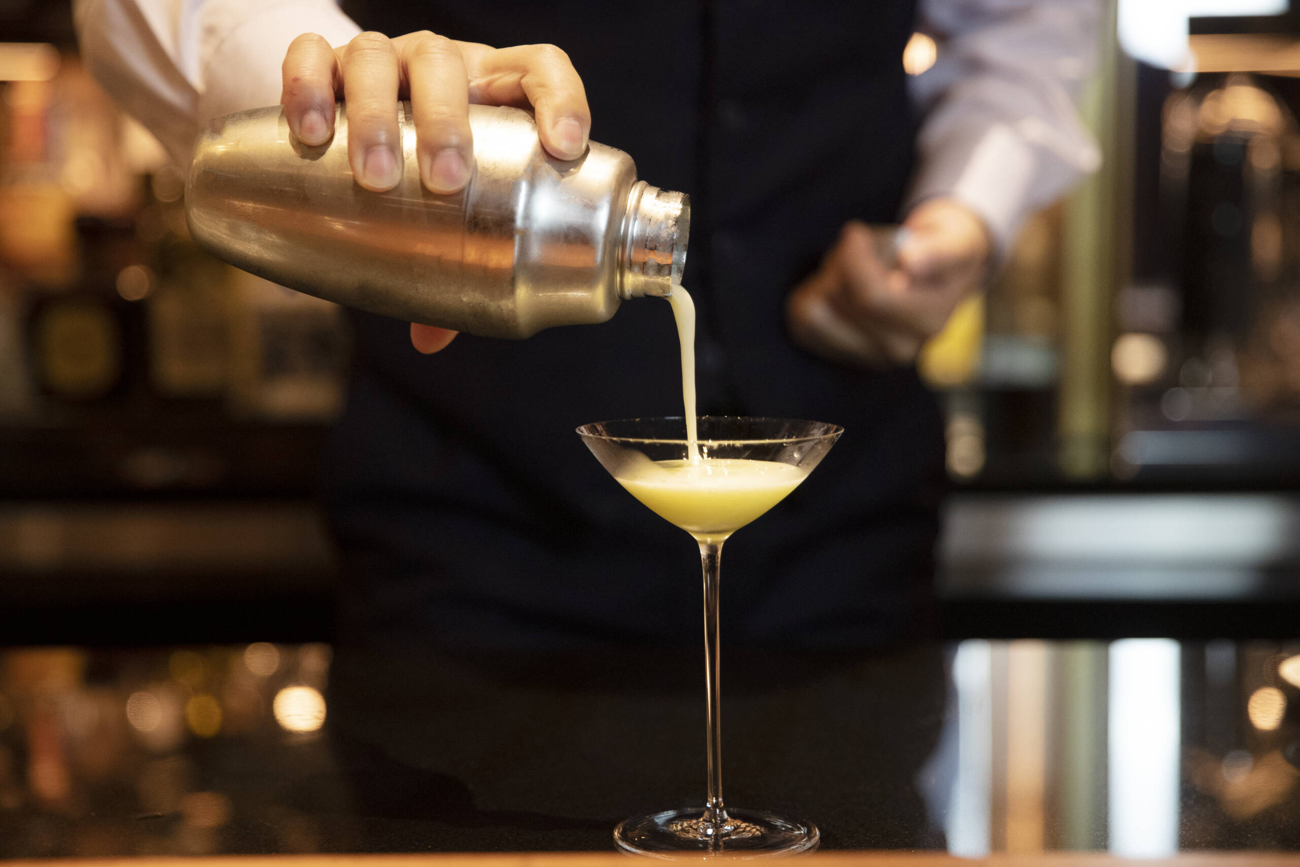 cocktail being poured into a glass